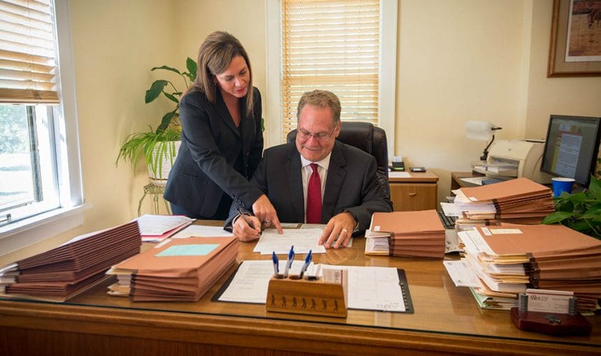 Attorney Daniel E. Phillips and assistant reviewing legal documents.